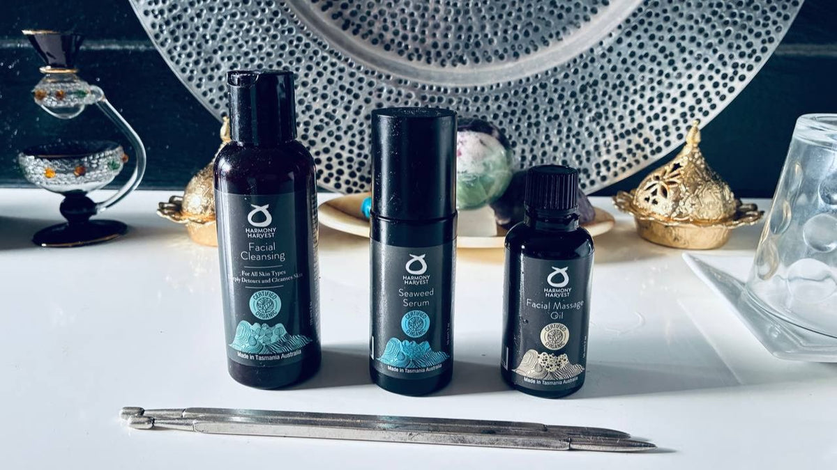 Harmony Harvest Facial Cleansing, Seaweed Serum and Facial Massage Oil on a dressing table, each labelled certified organic and made in Tasmania, Australia.